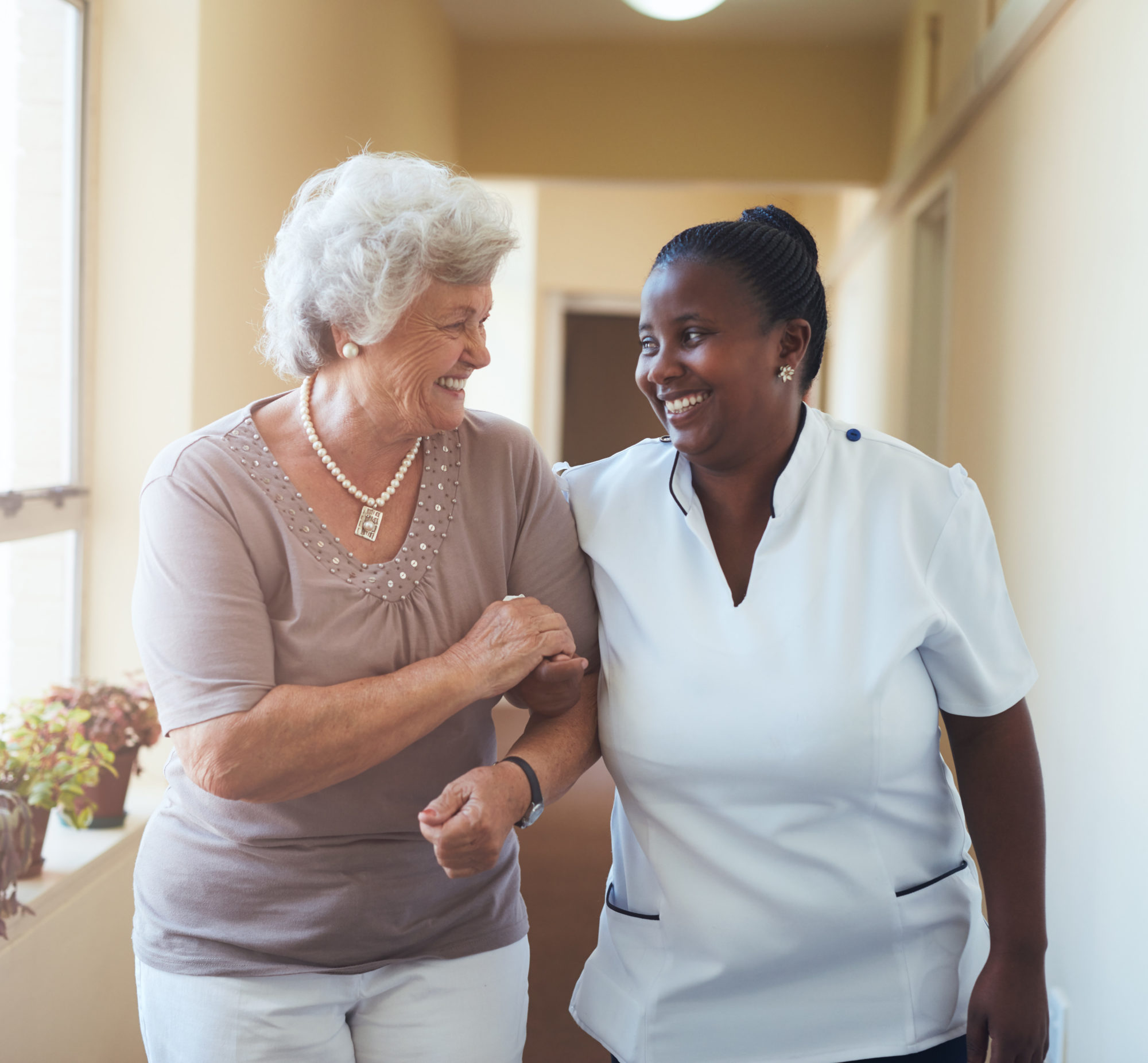 A nurse and patient walking together and smiling